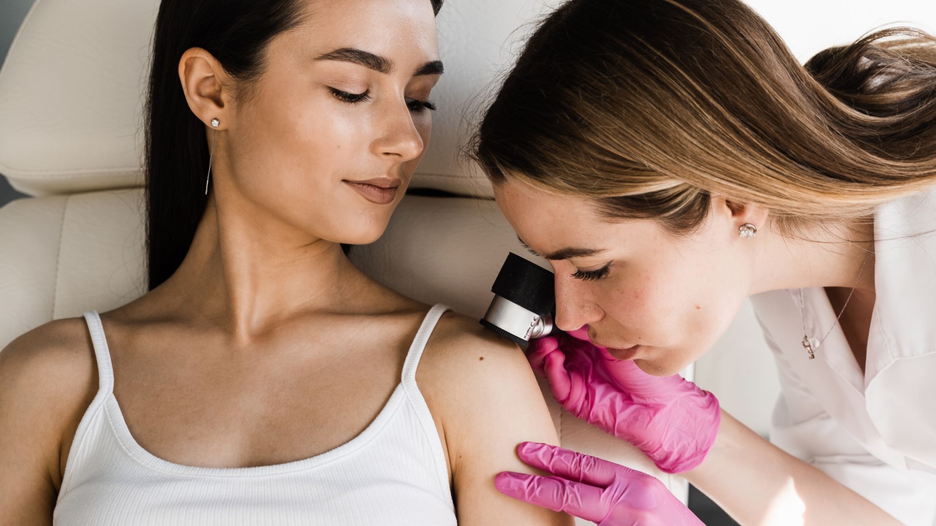 Una dottoressa dermatologa controlla la pelle della paziente