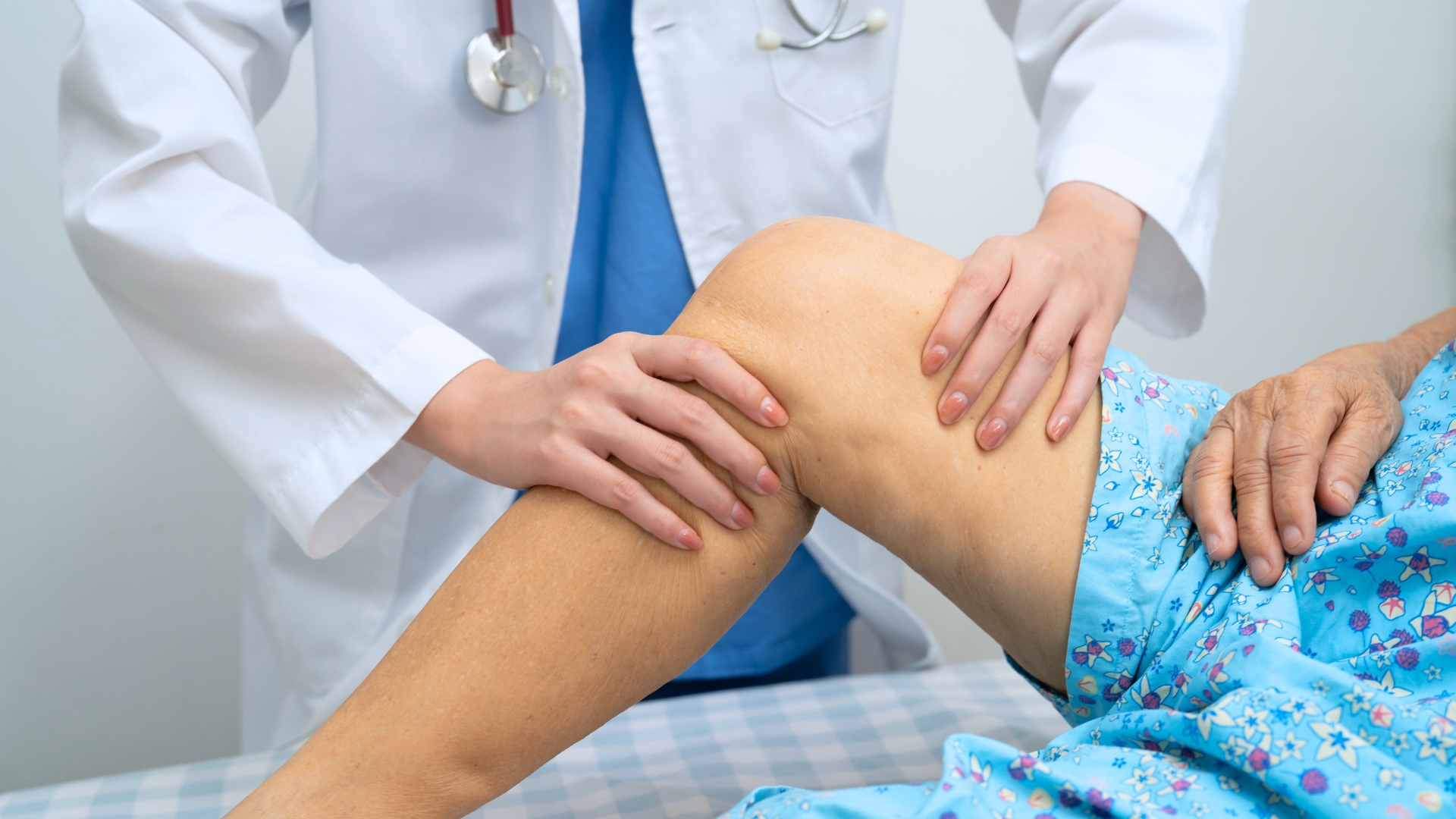 Un dottore fa un massaggio al ginocchio di una paziente all'interno dell'ambulatorio.