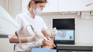 Una dottoressa controlla il cavo orale del paziente.