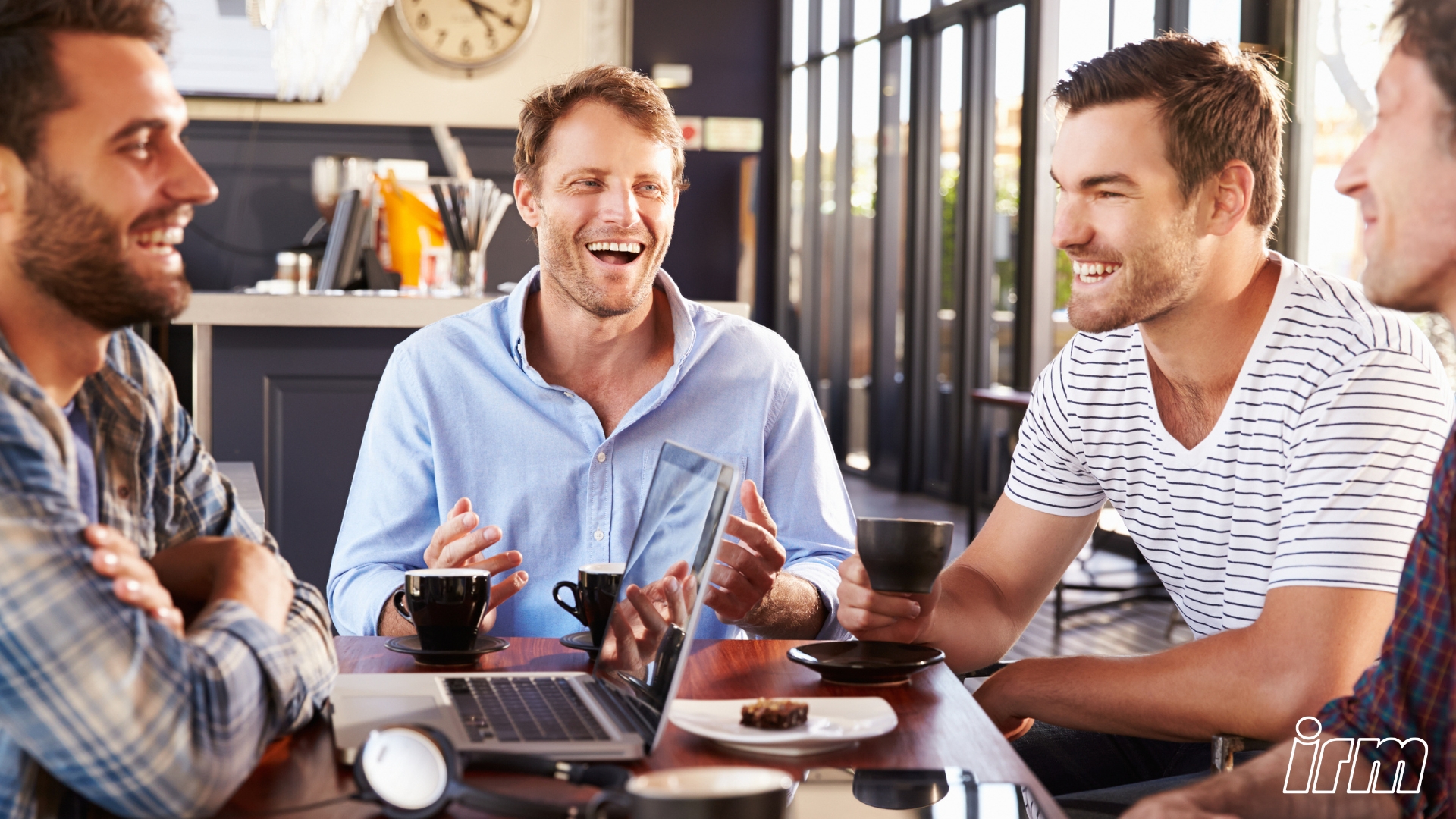 L'immagine rappresenta un gruppo di uomini giovani a un tavolo.
