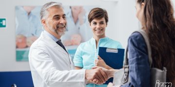 Un medico stringe la mano al paziente-