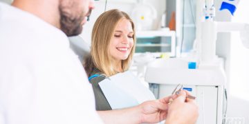 L'immagine rappresenta una ragazza in uno studio dentistico.