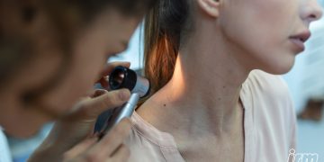 La foto rappresenta una donna che va dal medico dermatologo.
